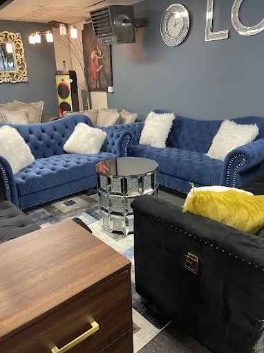 Blue tufted sectional sofa with white fur pillows in modern living room