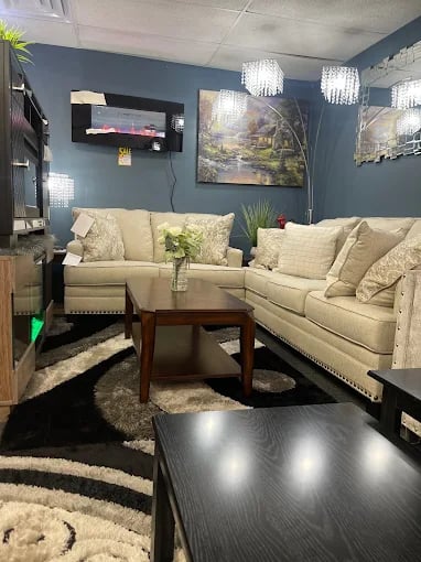 Cozy living room with beige sofas, blue walls, and crystal chandeliers