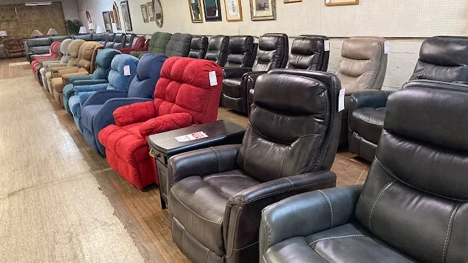 Rows of colorful leather recliners displayed in a furniture store showroom